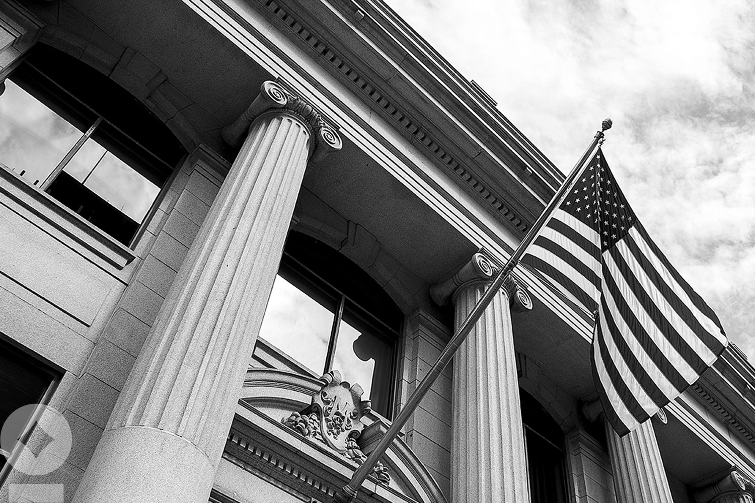 American flag flying over government building in city,
