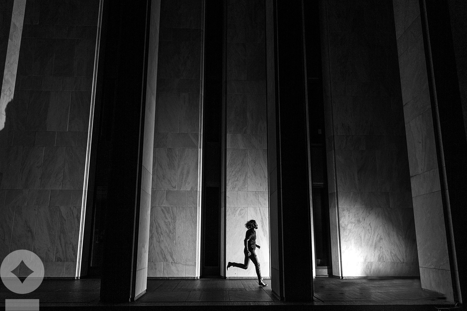 American flag flying over government building in city, blue sky and clouds